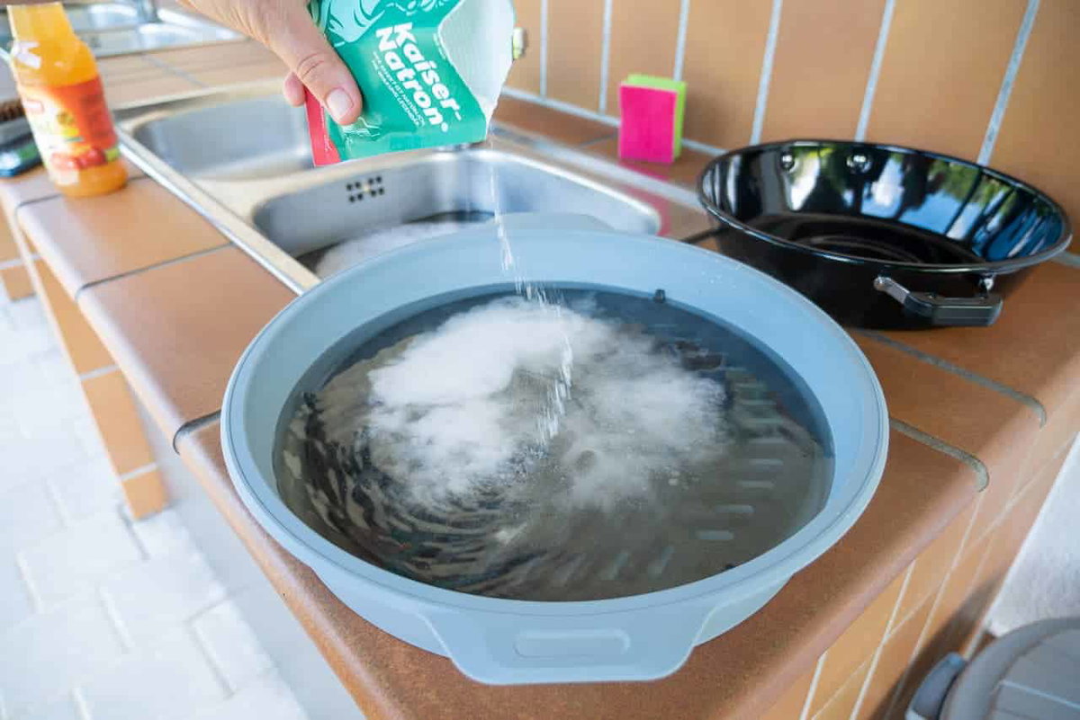 Cleaning a dirty grill grate with baking soda and vinegar.