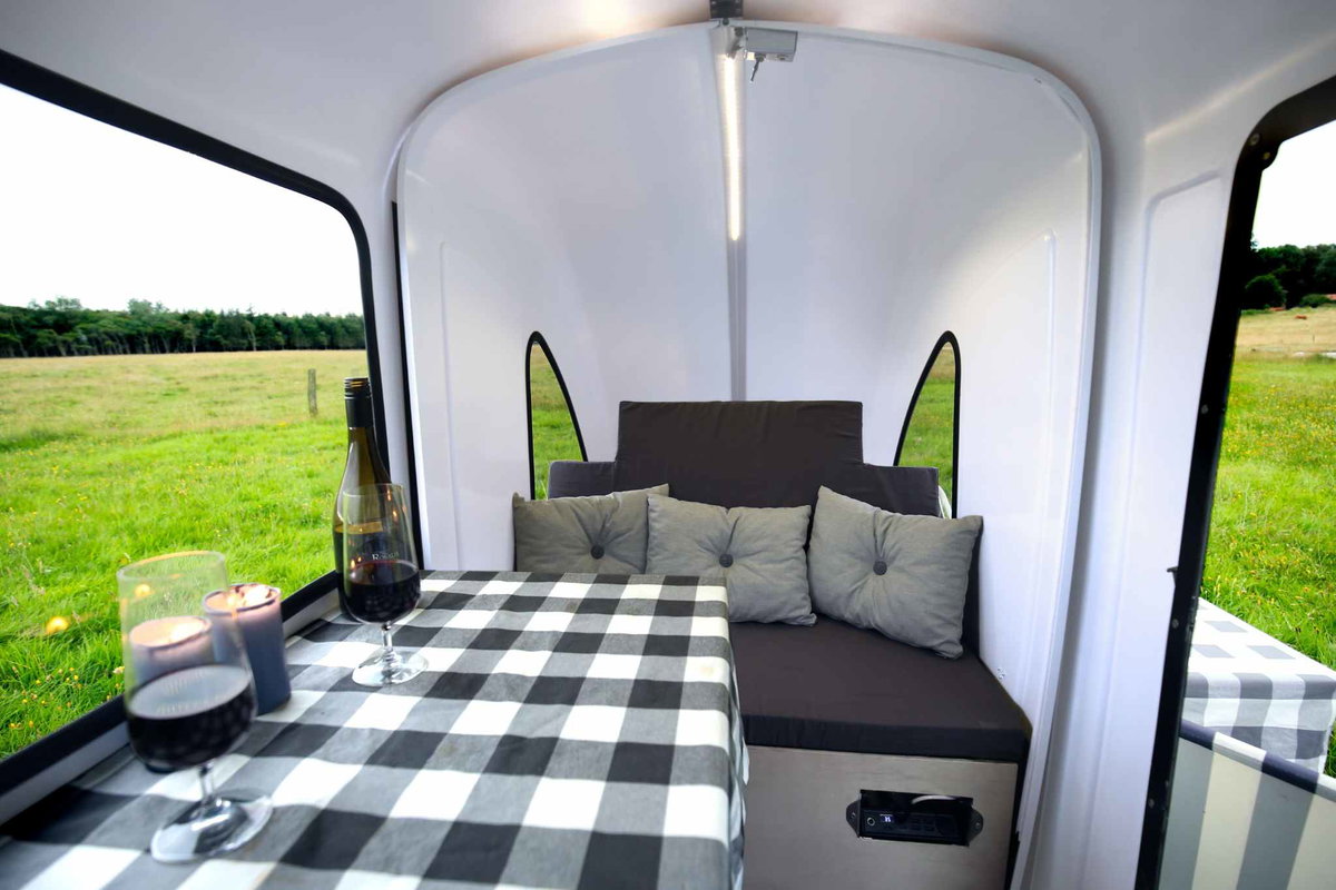 During the day, the sleeping area can be converted into a small seating area with table. (c) TMP Aps.