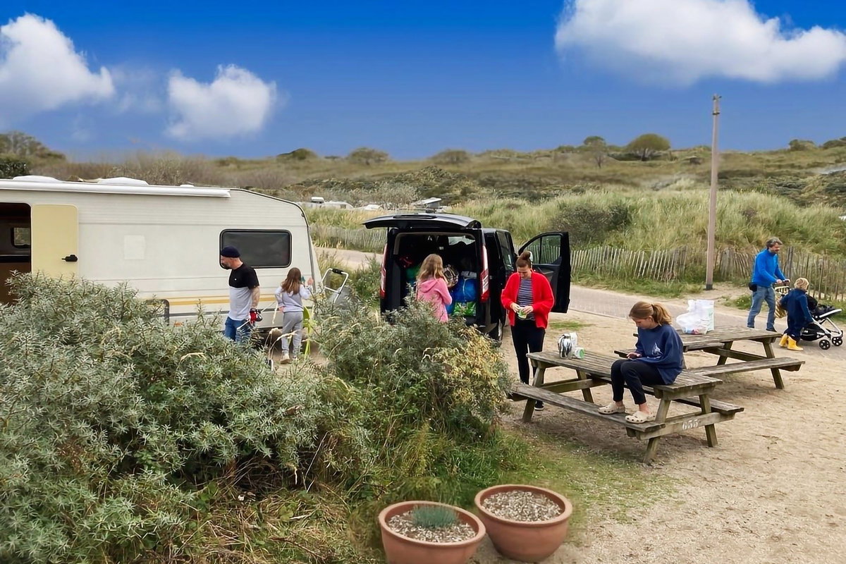 Checklist: Camping with a child - Family in front of a caravan on a campsite