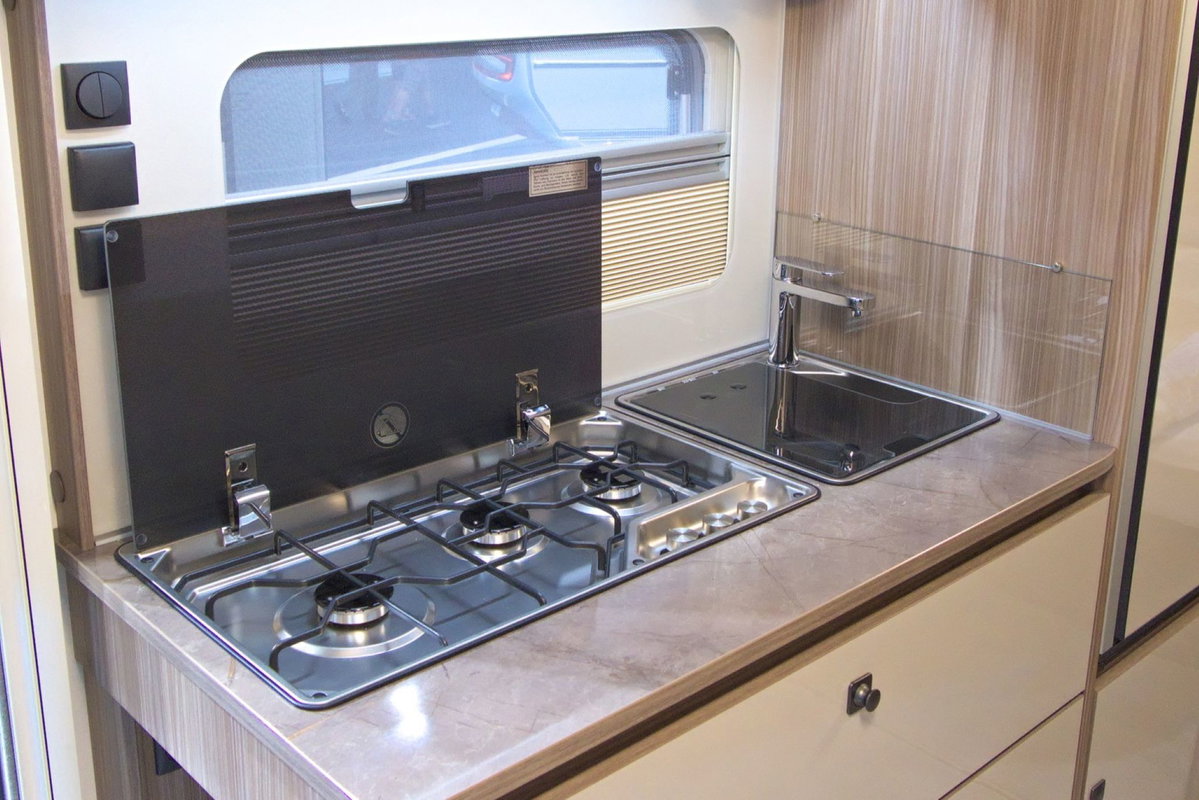 Fendt Tendenza 560 SFDW at Caravan Salon 2026: Kitchen unit with 3-burner stove and sink.