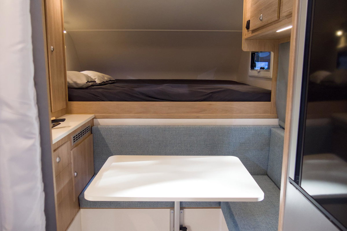 Tischer 200 Superlight auf dem Caravan Salon 2026: Blick auf das Bett und die Sitzgruppe.