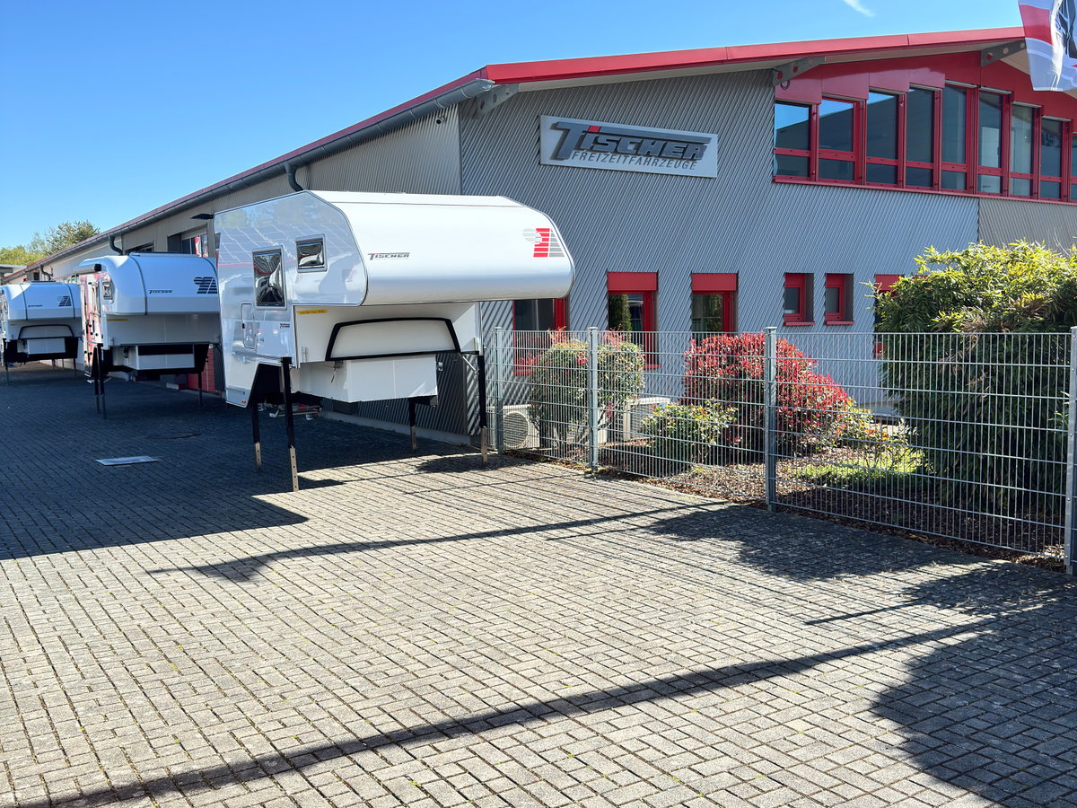 A Tischer slide-in camper, detached from its pickup